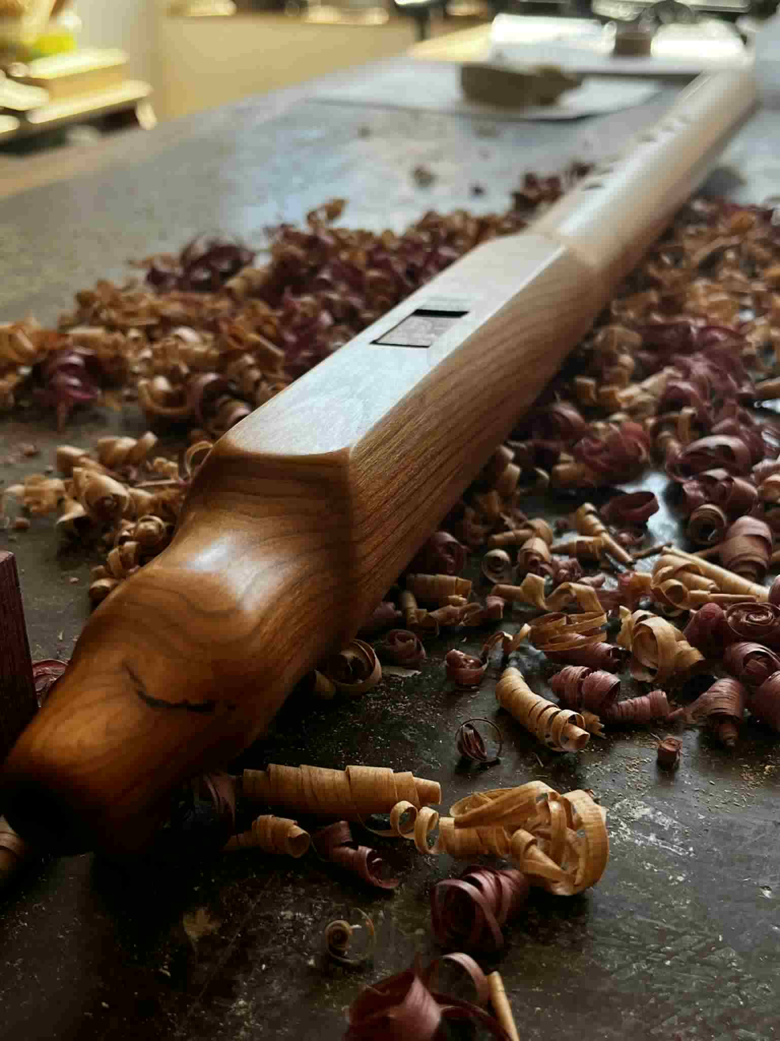 River Song walnut flute — full body view on the workshop bench, warm honey-to-espresso grain gradient